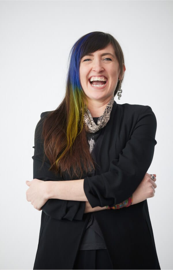 Cheerful professional in black business attire with arms crossed and a large smile