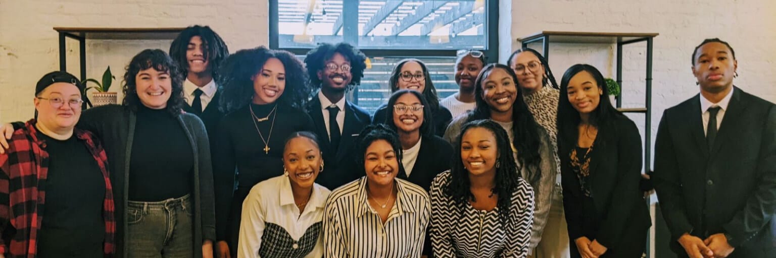 Smiling professionals gathered for a group photo in an office environment