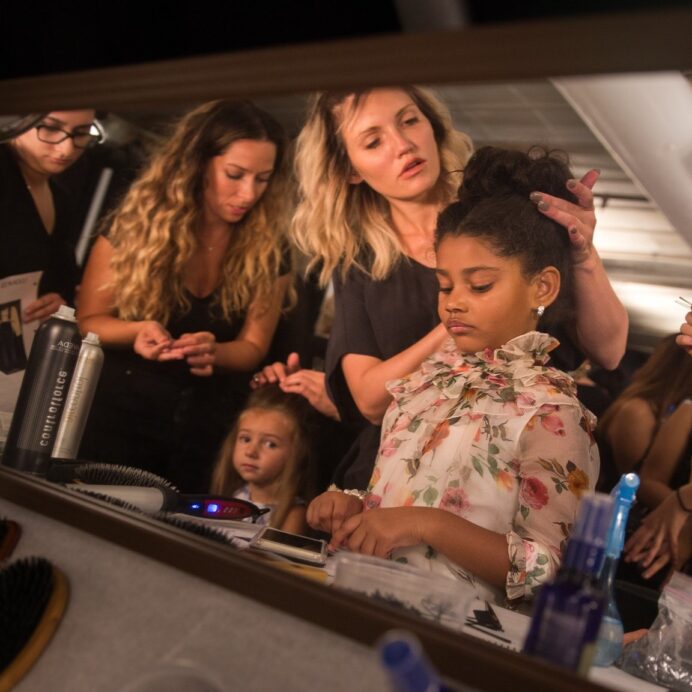 Young girl getting ready with beauty team surrounding her