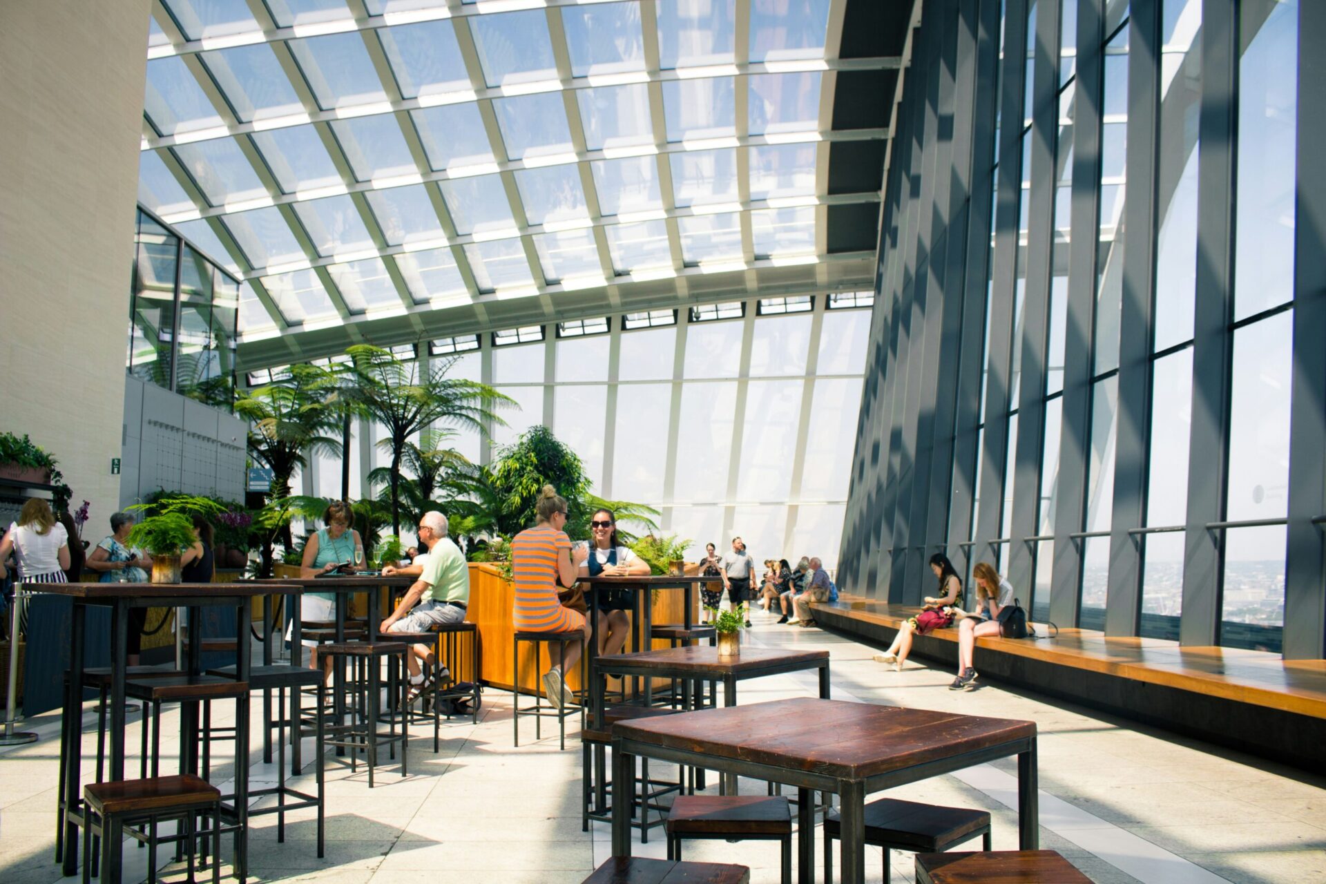 People sitting in an open space cafe with large glass windows