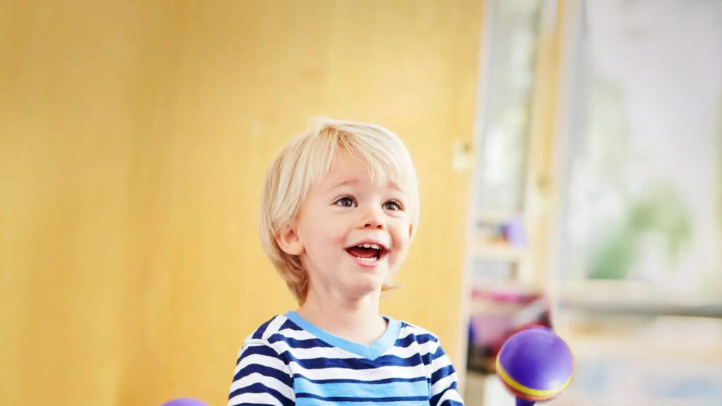 Child smiling in front of a bright colored background