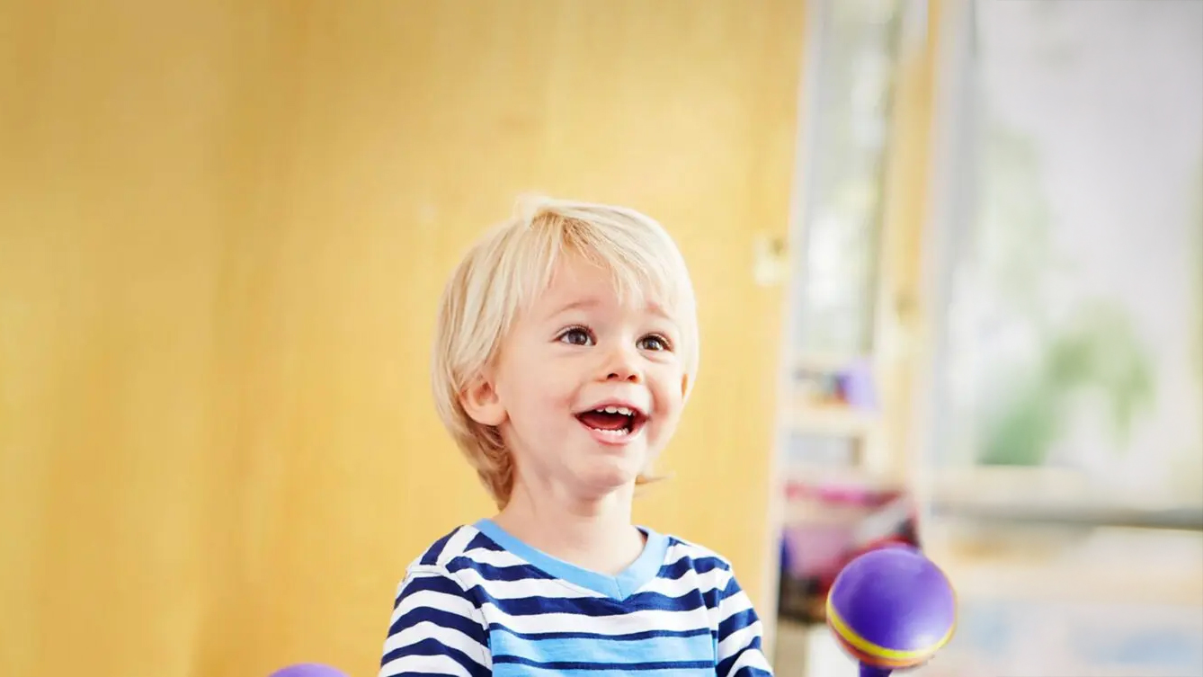 Child smiling in front of a bright colored background
