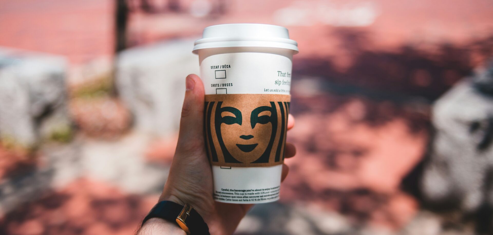 Person holding a starbucks coffee cup