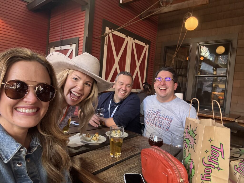 Amp employees smiling for a picture while sitting outside at a restaurant