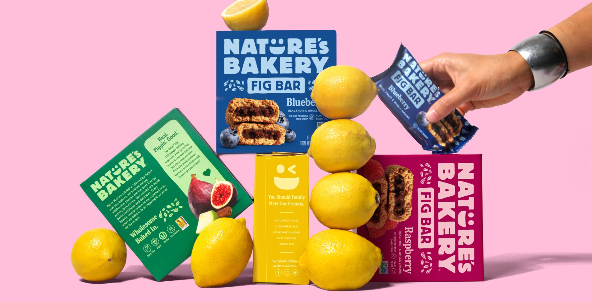 Boxes of Nature's Bakery bars stacked on top of each other with lemons beside them