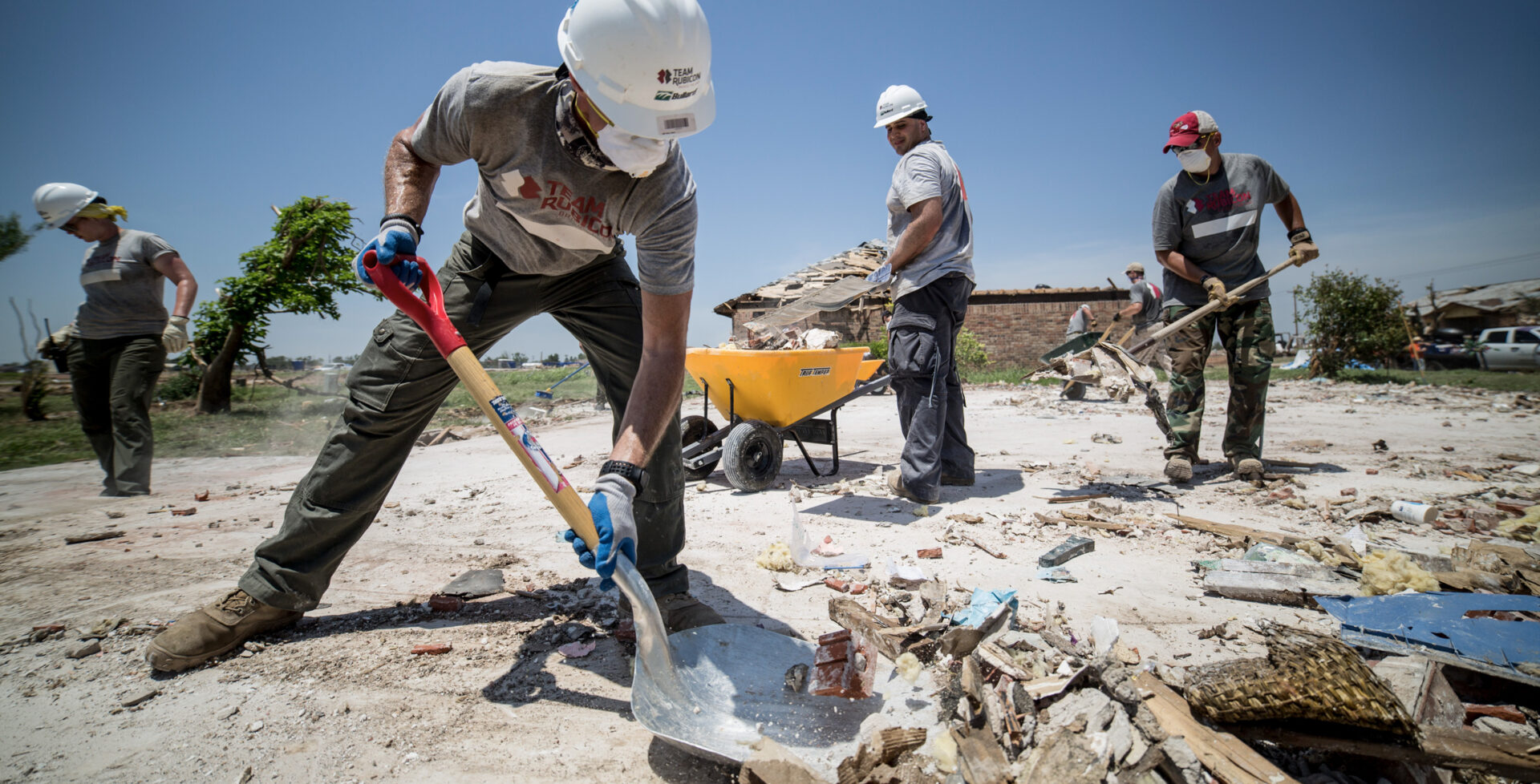 Team Rubicon in action – Men in construction safety equipment clearing debris from a disaster