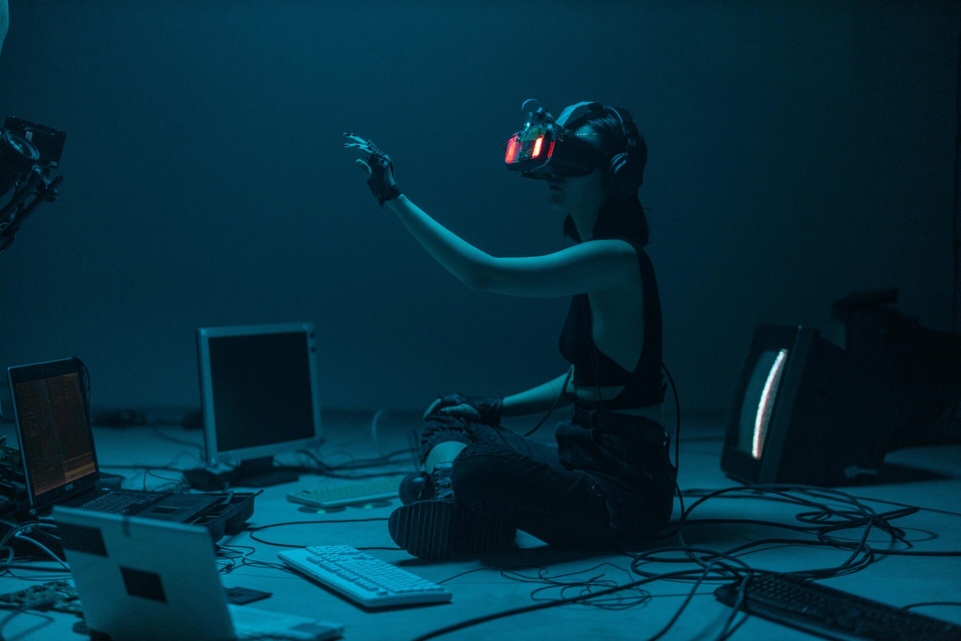woman wearing VR headset in dark room reaching out