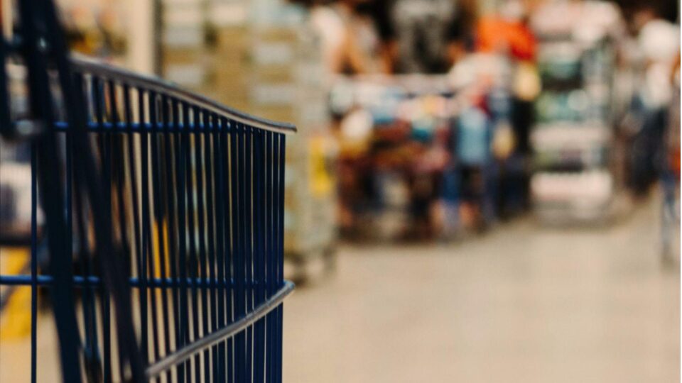 image of off-center shopping cart in focus with blurred grocery store in background