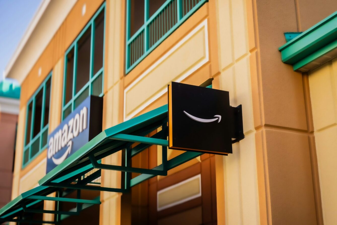 A photo of an Amazon storefront in a brick building with a green awning and Amazon branding
